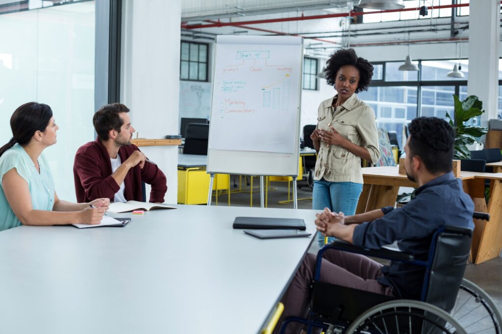 Business executives discussing over flip chart during meeting